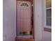 Close-up of a pink front door with half-round window and brick flooring, welcoming guests into the home at 910 Eagles Lndg, Leesburg, FL 34748