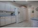 Clean kitchen featuring white cabinets, appliances, and light countertops with a view to hallway at 910 Eagles Lndg, Leesburg, FL 34748