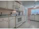 Bright kitchen featuring white cabinets and appliances, complemented by light countertops and modern flooring at 910 Eagles Lndg, Leesburg, FL 34748
