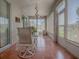 Enclosed sunroom featuring tile floors, neutral walls, a ceiling fan, and white patio furniture to enjoy the outdoors indoors at 910 Eagles Lndg, Leesburg, FL 34748