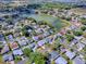 Overhead shot of a single-story home with a gray roof near a picturesque lake, surrounded by a lush community at 1010 Ventura Dr, The Villages, FL 32159