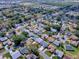 Aerial view shows a single-story home in a suburban neighborhood with mature trees and well-maintained lawns at 1010 Ventura Dr, The Villages, FL 32159