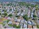 Drone shot showcasing a single-story home with a two-car garage, set among other homes in a leafy neighborhood at 1010 Ventura Dr, The Villages, FL 32159
