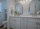 Bright bathroom with double sink vanity, modern fixtures, arched mirrors, and plenty of storage space at 1010 Ventura Dr, The Villages, FL 32159