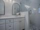 Bathroom featuring a double sink vanity, arched mirrors, a glass-enclosed shower, and modern fixtures at 1010 Ventura Dr, The Villages, FL 32159