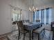 Cozy dining room features stylish chandelier, table with seating, and sliding glass door to a bright sunroom at 1010 Ventura Dr, The Villages, FL 32159