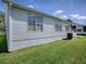 Exterior view of the side of the home with vinyl siding and grass yard at 1010 Ventura Dr, The Villages, FL 32159