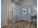 Bright foyer with wood floors, a frosted sliding barn door, and decorative front door with sidelights at 1010 Ventura Dr, The Villages, FL 32159