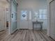 Inviting foyer featuring wood-look floors, a decorative front door, and a stylish side table with lamp at 1010 Ventura Dr, The Villages, FL 32159