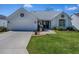 Inviting single-story house with lush green lawn and driveway leading to an attached garage, perfect for families at 1010 Ventura Dr, The Villages, FL 32159