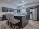 This kitchen boasts gray cabinetry, stainless steel appliances, and a spacious island at 1010 Ventura Dr, The Villages, FL 32159