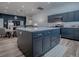 The kitchen overlooks the living area and features gray cabinetry and a center island at 1010 Ventura Dr, The Villages, FL 32159