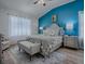 Bright main bedroom with vaulted ceiling, featuring a plush bed, a sitting bench, and a large window at 1010 Ventura Dr, The Villages, FL 32159