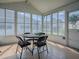 Sunroom with multiple windows, tile flooring, and a table with four chairs at 1010 Ventura Dr, The Villages, FL 32159