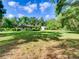Spacious backyard with mature trees, detached storage shed, and lush lawn at 10166 Cr 671, Bushnell, FL 33513