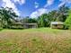 Expansive backyard featuring lush lawn, detached storage shed, and a rear view of the home at 10166 Cr 671, Bushnell, FL 33513