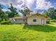 Back of home with door to backyard and view of the grassy lawn at 10166 Cr 671, Bushnell, FL 33513
