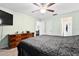 Well-lit primary bedroom featuring soft green walls and multiple closets for ample storage at 10339 Patrick Dr, Leesburg, FL 34788