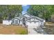 Charming single-story home featuring mature trees, a two-car garage, and a well-manicured front yard at 10339 Patrick Dr, Leesburg, FL 34788