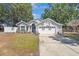 Charming single-story home with a well-manicured lawn and a two car garage at 10339 Patrick Dr, Leesburg, FL 34788