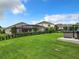 View of the green lawn features a hot tub and pool in the neighboring yard that adds to this home's backyard appeal at 1051 Nathan Ridge Rd, Clermont, FL 34715