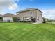 Well-maintained backyard featuring a lush green lawn and a modern two-story home with a sliding glass door and windows at 1051 Nathan Ridge Rd, Clermont, FL 34715