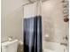 Bathroom featuring a shower/tub combo and a toilet with a tile surround at 1051 Nathan Ridge Rd, Clermont, FL 34715