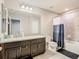 Bright bathroom featuring a vanity with dual sinks, a toilet, and a shower with a curtain at 1051 Nathan Ridge Rd, Clermont, FL 34715
