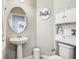 Charming bathroom featuring a pedestal sink and storage unit, with a decorative 'Bath' sign at 1051 Nathan Ridge Rd, Clermont, FL 34715