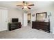 Bedroom showcasing a dark wood dresser, ceiling fan, and gray carpeting at 1051 Nathan Ridge Rd, Clermont, FL 34715