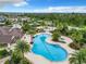 Aerial view of community pool featuring winding design, lush landscaping, splashpad, and shade at 1051 Nathan Ridge Rd, Clermont, FL 34715