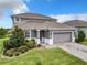 Elegant two-story home showcasing a landscaped front yard, neutral color scheme, and a two-car garage at 1051 Nathan Ridge Rd, Clermont, FL 34715