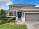 Beautiful home exterior featuring a gray facade, manicured lawn, and a two-car garage at 1051 Nathan Ridge Rd, Clermont, FL 34715
