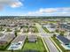 A high aerial shot displays the neighborhood's layout and green spaces under a partly cloudy sky at 1051 Nathan Ridge Rd, Clermont, FL 34715