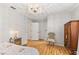 Airy bedroom featuring hardwood floors, crystal chandelier, and natural light from three entry doors at 10689 Se 174Th Loop, Summerfield, FL 34491