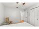 Bright bedroom featuring a white quilt, wood accent table and chair, ceiling fan and standard-sized closet at 10689 Se 174Th Loop, Summerfield, FL 34491