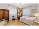 Beautiful bedroom with vintage armoire, crystal chandelier, and large windows with sheer curtains at 10689 Se 174Th Loop, Summerfield, FL 34491