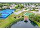 Aerial view highlights the community's amenities, including tennis courts, shuffleboard, and a scenic pond at 10689 Se 174Th Loop, Summerfield, FL 34491