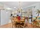 Bright dining area with wood floors, chandelier, and sliding glass doors leading to a screened porch, creating inviting space at 10689 Se 174Th Loop, Summerfield, FL 34491
