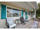 Inviting front porch with cozy seating, featuring teal shutters and a charming front door with a wreath accent at 10689 Se 174Th Loop, Summerfield, FL 34491