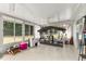 This sunroom features a swing, tile flooring, and backyard views through the large windows at 10689 Se 174Th Loop, Summerfield, FL 34491