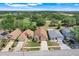 An aerial view of a neighborhood showcasing well-maintained homes and lush green landscaping, bordering a beautiful golf course at 1159 Greenley Ave, Groveland, FL 34736
