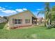 Charming backyard featuring a well-maintained lawn, a screened patio, and a beautifully landscaped area at 1159 Greenley Ave, Groveland, FL 34736