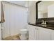 Bathroom with granite countertop, white vanity, toilet, white shower curtain, and tile flooring at 1159 Greenley Ave, Groveland, FL 34736