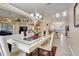 Bright dining room with modern chandelier, glass table and views into the kitchen and living area at 1159 Greenley Ave, Groveland, FL 34736
