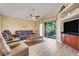 Cozy living room with leather furniture, ceiling fan, and sliding doors to the outdoor patio at 1159 Greenley Ave, Groveland, FL 34736