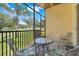 Relaxing screened patio with comfortable seating and views of a lush green lawn and mature trees at 1159 Greenley Ave, Groveland, FL 34736