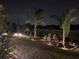 Evening view of a backyard landscaped with garden lights and mature trees at 11860 Se 179Th St, Summerfield, FL 34491