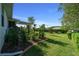 Spacious backyard featuring well-maintained lawn, landscaping, garden bed, and covered patio area for outdoor enjoyment at 11860 Se 179Th St, Summerfield, FL 34491