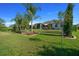 Beautifully landscaped backyard with lush green lawn, mature trees, and a shaded pergola at 11860 Se 179Th St, Summerfield, FL 34491